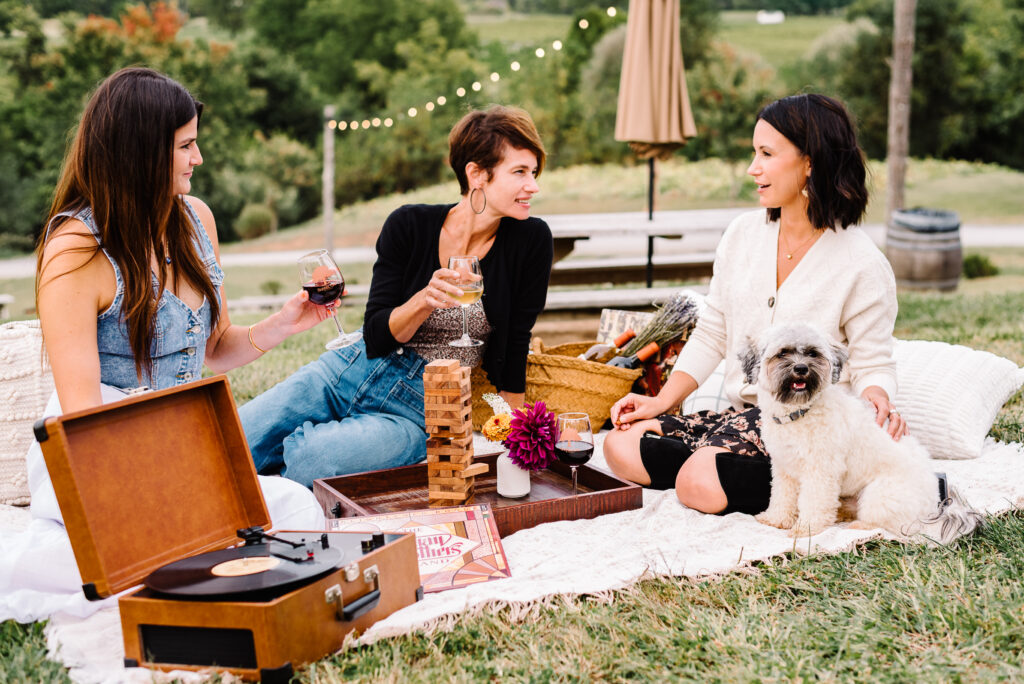 Friends enjoying wine and music during Golden Hour at Barrel Oak Winery with picnic setup
